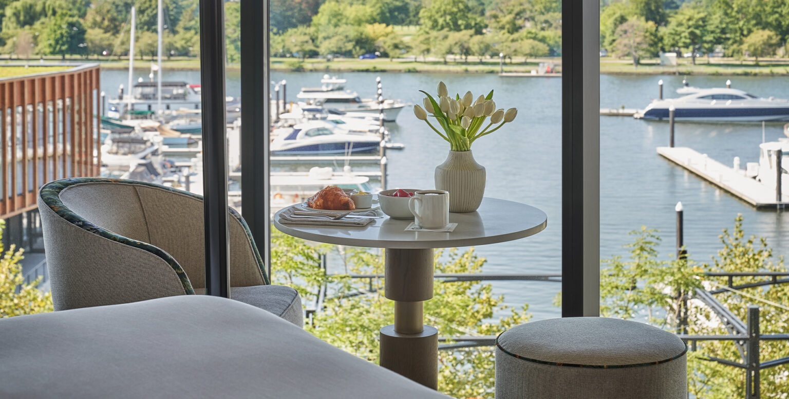 Pastries and coffee on a table overlooking the Washington Harbor in a guestroom at Pendry Washington DC &ndash; The Wharf